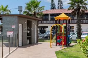 a playground in front of a building at Solar do Atlântico 214 in Bombas