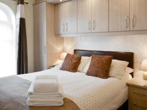 a bedroom with a bed with white sheets and pillows at Eldin Hall Cottage 1 - Uk2483 in Cayton