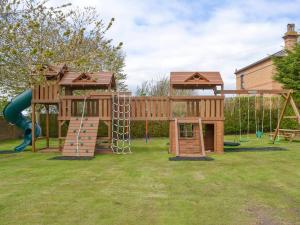 a playground with two play structures and a slide at Eldin Hall Cottage 1 - Uk2483 in Cayton