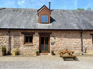 a stone cottage with a table in front of it at Bramble Cottage in Newland +3 photos