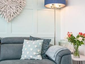 sala de estar con sofá con almohadas y lámpara en Blue Lobster, en Brixham