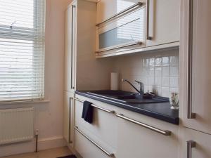 una cocina con fregadero y ventana en Ash Villas, en Southport