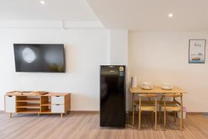 Un refrigerador negro en una habitación con una mesa. en Bangsaen Kaze, en Chonburi