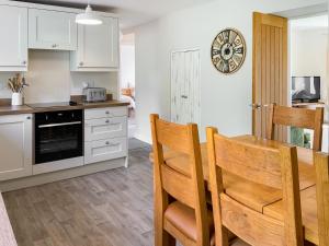 a kitchen and dining room with a table and chairs at Southways Cottage in Cumwhinton