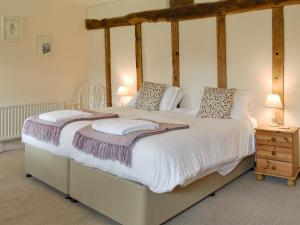 Wootton Glanville丘吉尔乡村别墅的一间卧室配有一张带白色床单的四柱床