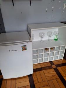 a small white cabinet with wine glasses in it at Suite 1076 in Belém