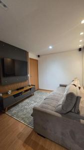 a bedroom with a large bed and a flat screen tv at Belíssimo Apartamento Aeroporto in Várzea Grande