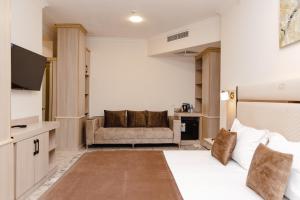 タシュケントにあるArt Dream Hotelのベッドとソファのあるホテルの部屋