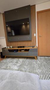 a bedroom with a large television on a wall at Belíssimo Apartamento Aeroporto in Várzea Grande