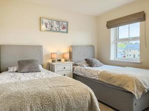 a bedroom with two beds and a window at Crawshaw Cottage in Buxton +9 photos