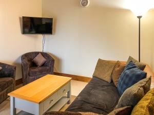 een woonkamer met een bank en een tafel bij Farmtoun Cottage in Forfar