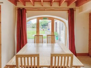 een eetkamer met een tafel en een groot raam bij Farmtoun Cottage in Forfar