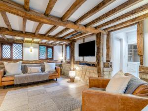 a living room with a couch and a tv at Waterside House in Knaresborough