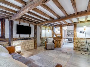 a living room with a couch and a tv at Waterside House in Knaresborough