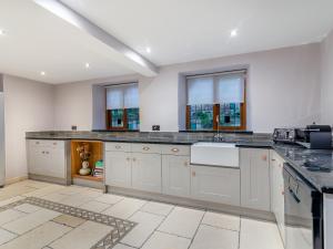 a kitchen with white cabinets and a counter top at Waterside House in Knaresborough +28 photos