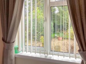 ein Fenster mit Blick auf einen Garten in der Unterkunft Bramley Lodge Annex in Clenchwarton + 7 Fotos