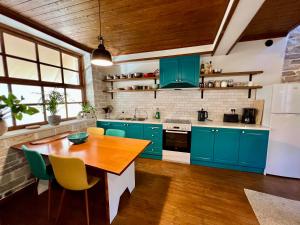 a kitchen with blue cabinets and a wooden table at Our Townhouse in Gjirokastër