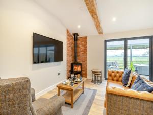 a living room with a couch and a tv at The Workshop - Uk42470 in Middleton