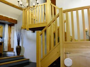 a wooden staircase in a house with a vase at Ty Cerrig Farmhouse in Banc-y-felin +12 photos