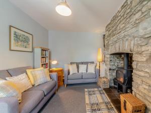 a living room with a couch and a stone fireplace at East Llwyn - Uk41756 in Rhyd Owen