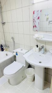 a white bathroom with a toilet and a sink at Z01 Furnished Studio Garden view International city in Dubai +24 photos