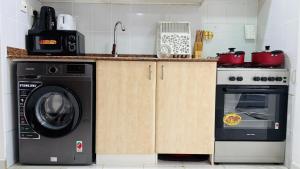 a kitchen with a washing machine and a stove at Z01 Furnished Studio Garden view International city in Dubai