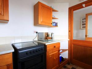 a kitchen with a black stove and a microwave at The Old Chandlery in Avoch +21 photos