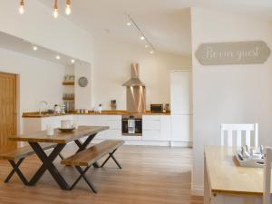 een keuken en eetkamer met een houten tafel en stoelen bij Redstones Cottage in Greasby