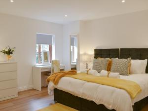 een slaapkamer met een groot bed en een bureau bij Redstones Cottage in Greasby