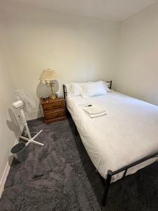 a bedroom with a bed and a table with a lamp at Goldwin's Place in Toronto