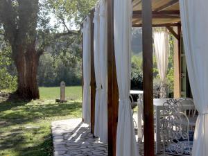 GhizzanoにあるVilla in Tuscany near Medieval Ghizzanoの白いカーテンとテーブルと椅子付きのポーチ