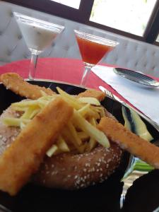 Un plato con una hamburguesa, patatas fritas y dos bebidas. en Stone dream, en Polje