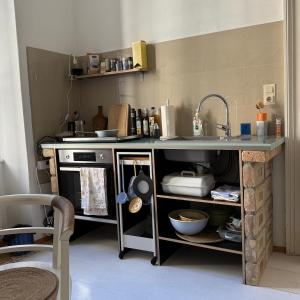 a kitchen with a counter with a sink and a stove at Palais am Park in Krems an der Donau