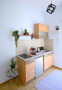 Una pequeña cocina con gabinetes de madera y un fregadero. en Verano Studios, 