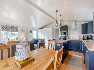 a kitchen and living room with a wooden table at Lilac Tree Lodge in Willington