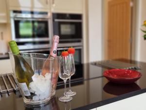 a counter with two glasses and a bottle of wine at Mow Barton in Wells +21 photos