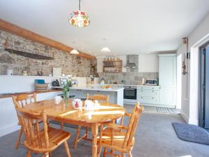 una cucina con tavolo e sedie in legno di The Woodshed a Sheepwash Altre 18 foto