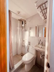 Un baño blanco con inodoro y lavabo. en G's Bnb, en Manila