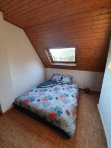 una piccola camera da letto con un letto in mansarda di Jolie maison - Vallée de la Bruche près des Vosges a Bourg-Bruche