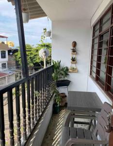a patio with a table and chairs on a balcony at Bau 420 HOSTAL in Cali