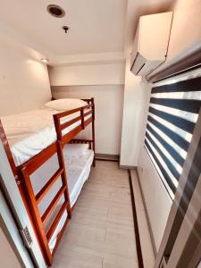 una habitación con dos literas y una ventana en G's Bnb, en Manila