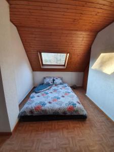 una camera da letto con un letto in mansarda con una finestra di Jolie maison - Vallée de la Bruche près des Vosges a Bourg-Bruche