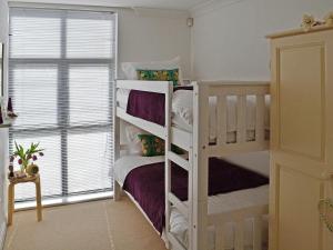 Un dormitorio con dos literas y una ventana. en Linhay Apartment, en St Austell 7 fotos más
