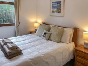 a bedroom with a white bed with pillows and a window at The Lodge in Uny Lelant +4 photos