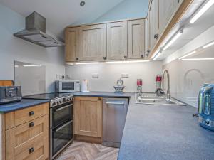 een keuken met houten kasten en roestvrijstalen apparatuur bij Walnut Cottage - Uk43995 in Fairfield