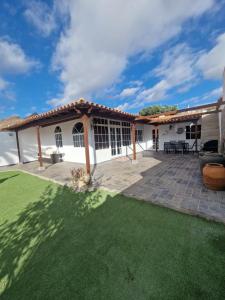 un patio con techo y césped verde en Villa Palmera Dorada, en Mogán