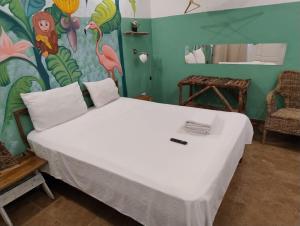 a bedroom with a large bed with a painting on the wall at Brisa de Alma Guesthouse in Bayahibe