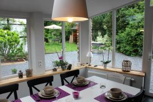a dining room with windows and a table and chairs at Le Néblon insolite in Ouffet