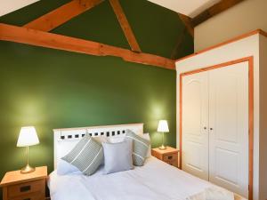una camera verde con un letto bianco e due lampade di Uk46555 - Ragleth a Church Stretton