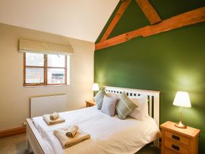 una camera verde con un letto e asciugamani di Uk46555 - Ragleth a Church Stretton